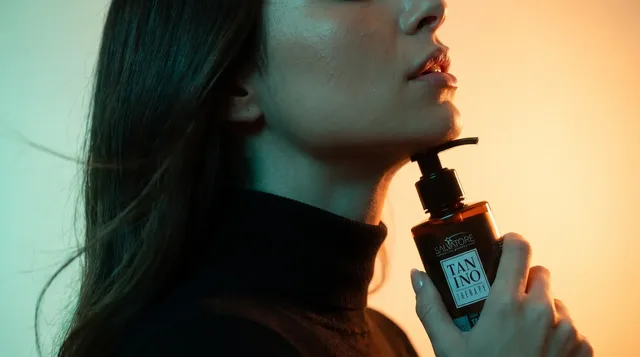 Mulher de perfil segurando o produto Tanino Therapy da HD Cosméticos junto ao queixo